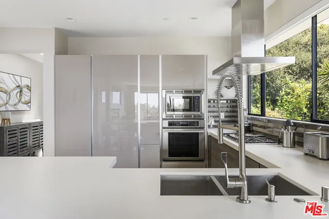 a kitchen with stainless steel appliances kitchen island granite countertop a stove a sink and a refrigerator