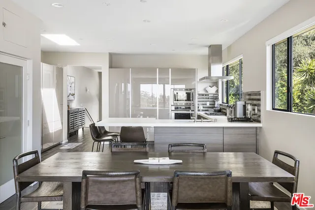 a dining table with chairs and view of kitchen