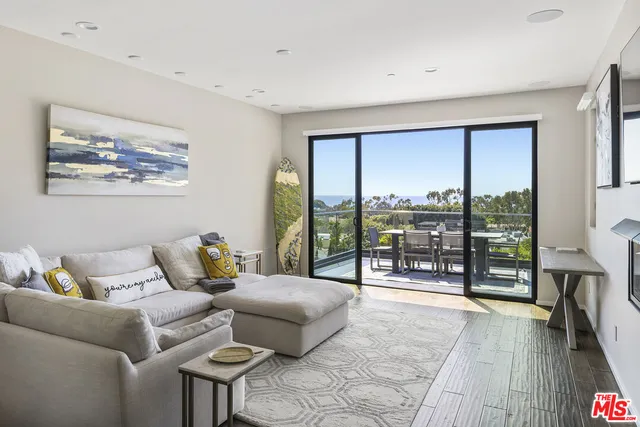 a living room with furniture and a floor to ceiling window