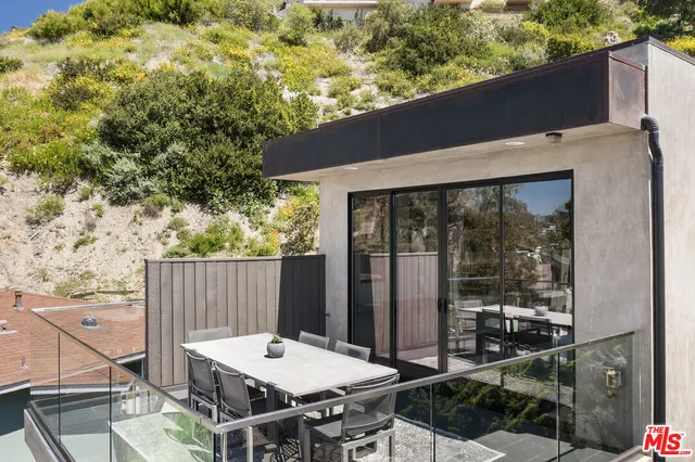 a view of a patio with table and chairs with wooden floor and fence