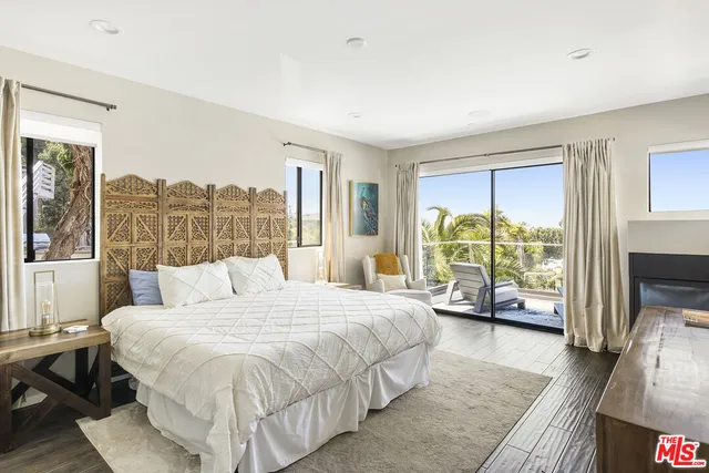 a bedroom with a bed and a large window