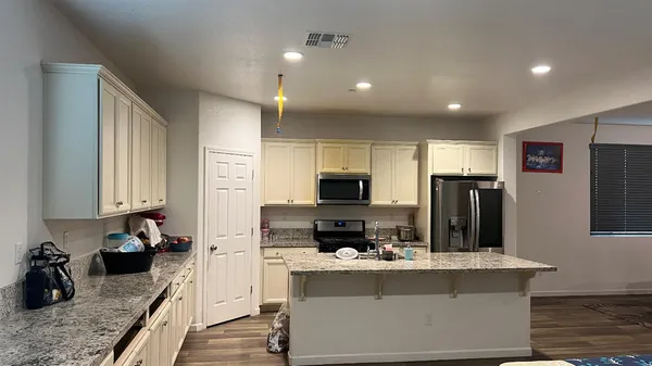 a kitchen with kitchen island a refrigerator stove and sink