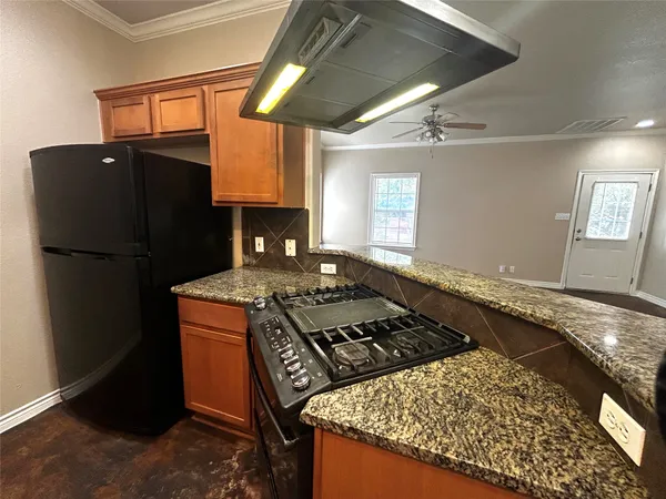 a kitchen with granite countertop a sink stove and cabinets
