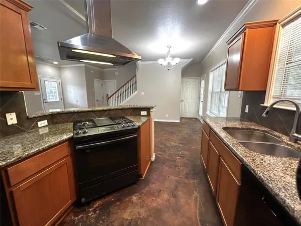 a large kitchen with granite countertop a stove and a sink