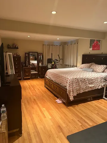 a bedroom with a large bed and wooden floor