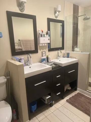 a bathroom with a double vanity sink mirror and toilet