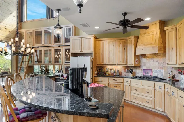 a kitchen with stainless steel appliances granite countertop a sink a stove and cabinets