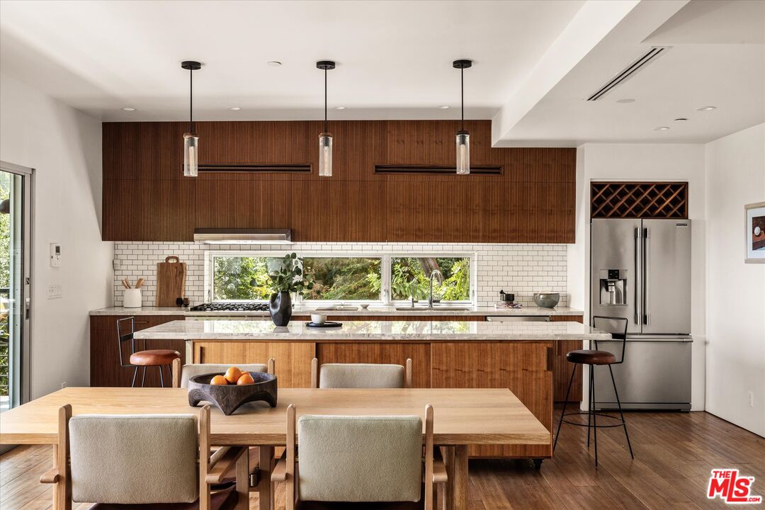 1072 Montecito Drive Los Angeles, CA 90031 - Photo 4 of 30 a kitchen with stainless steel appliances kitchen island granite countertop a table chairs in it and a window
