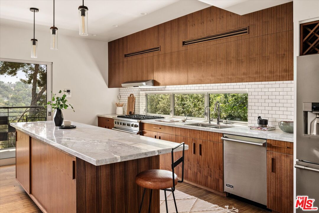 1072 Montecito Drive Los Angeles, CA 90031 - Photo 5 of 30 a kitchen with a sink a window and chairs