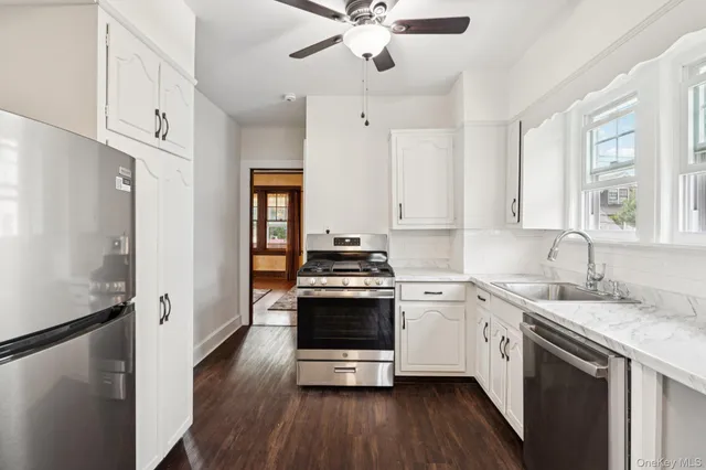 a kitchen with stainless steel appliances a stove a sink and a refrigerator