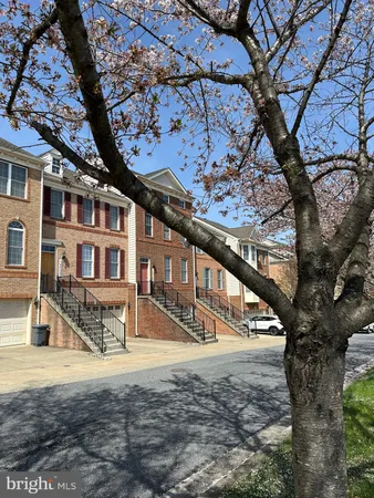 a view of a house with large tree and wooden fence