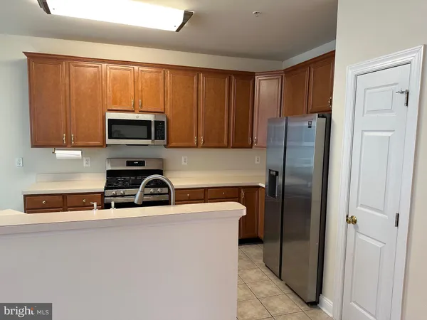 a kitchen with stainless steel appliances granite countertop a sink counter space cabinets and a large window