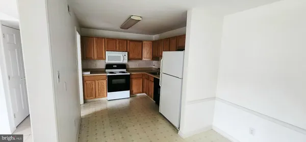 a kitchen with a refrigerator sink and cabinets