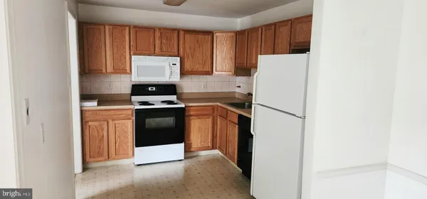 a kitchen with a refrigerator sink and cabinets