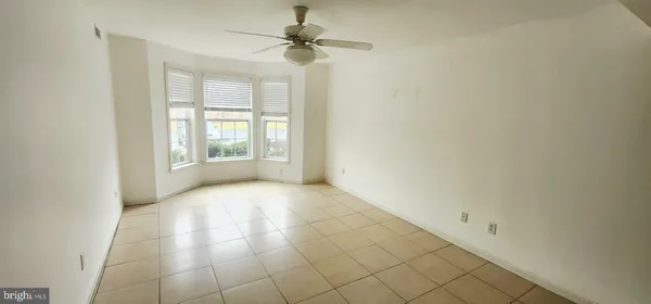 an empty room with windows and fan