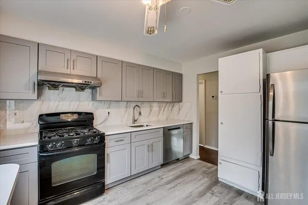 a kitchen with stainless steel appliances a stove a sink and a refrigerator