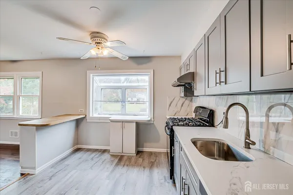 a kitchen with stainless steel appliances granite countertop a sink dishwasher and cabinets with wooden floor