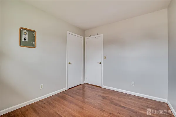a view of an empty room with wooden floor