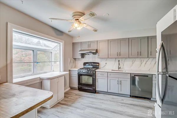 a kitchen with a stove a sink and a refrigerator