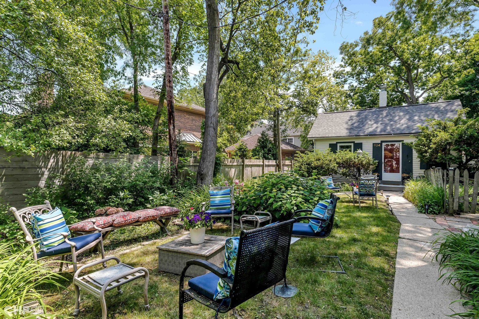 936 Spruce Street Winnetka, IL 60093 - Photo 31 of 38 a view of a patio with couches table and chairs potted plants and large tree