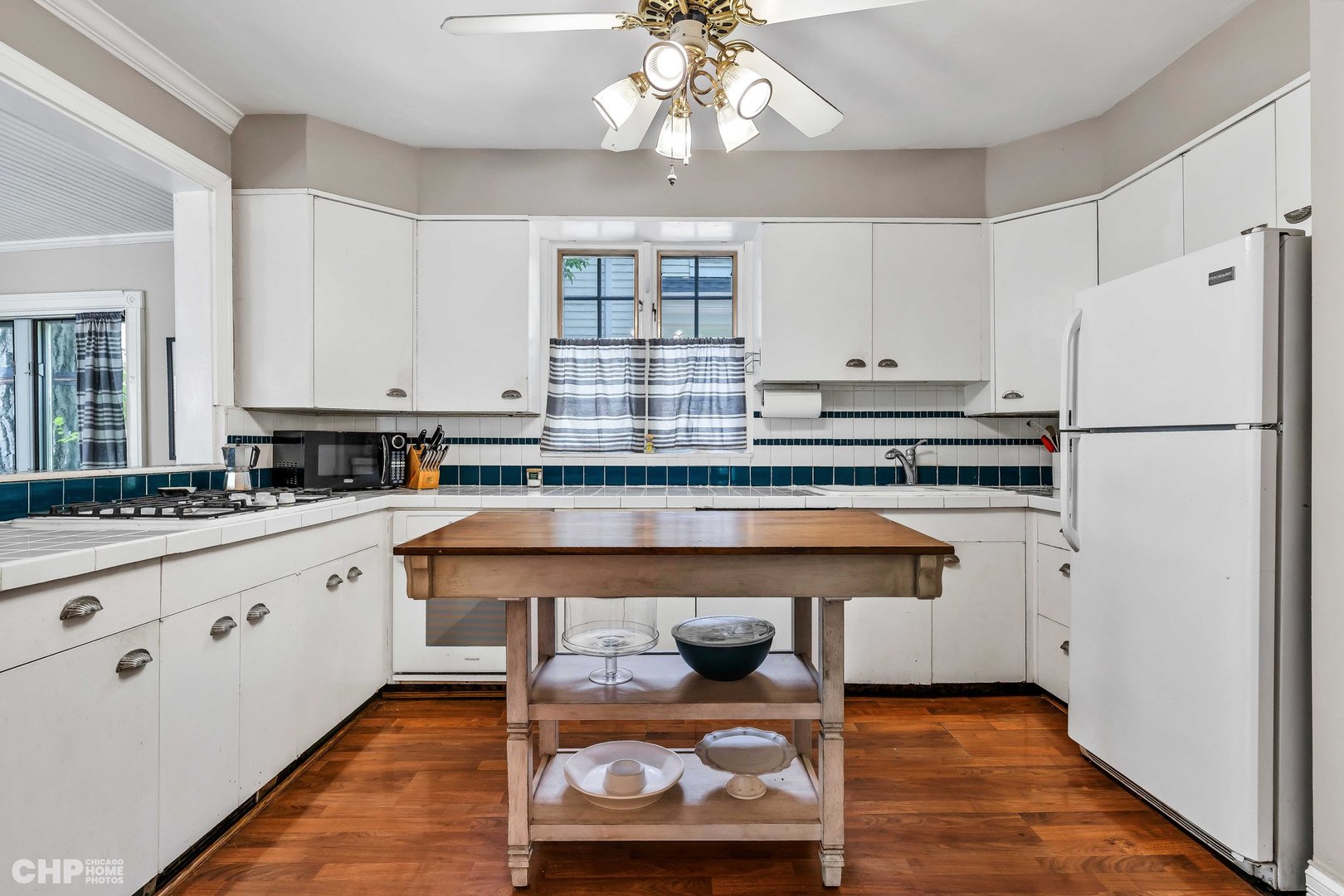 936 Spruce Street Winnetka, IL 60093 - Photo 10 of 38 a kitchen with granite countertop a refrigerator a stove a sink dishwasher and white cabinets with wooden floor