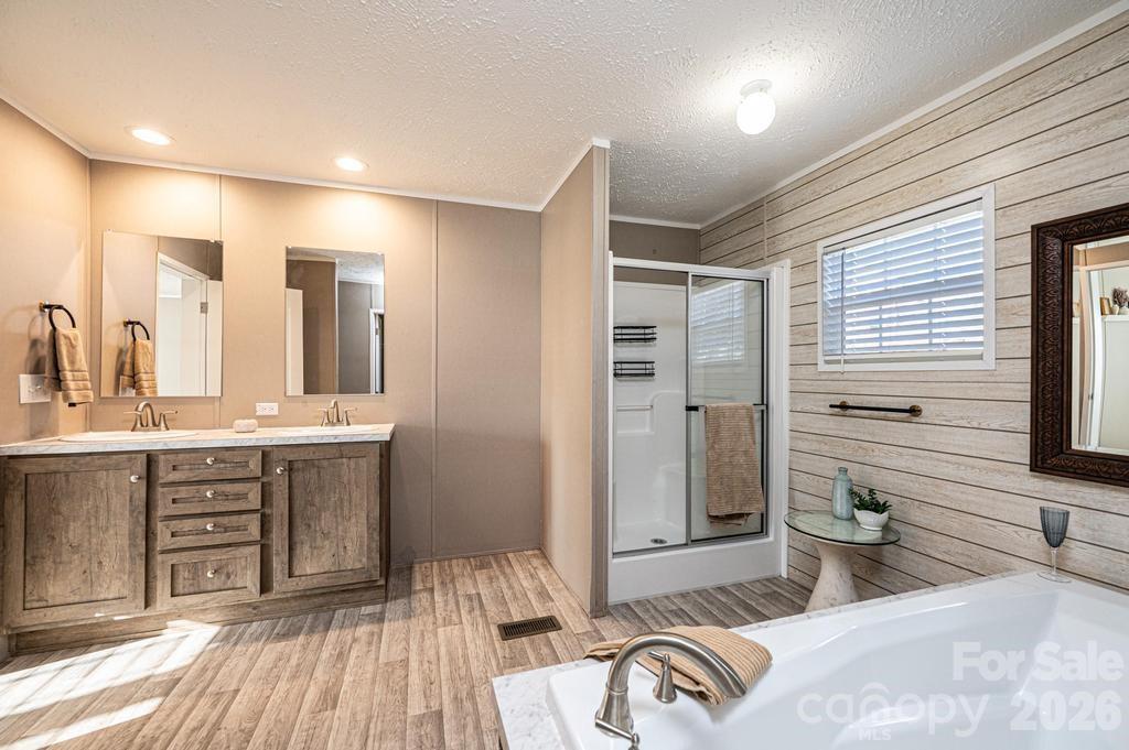 1070 Cottrell Hill Road Lenoir, NC 28645 - Photo 19 of 41 a spacious bathroom with a double vanity sink a mirror and a bathtub