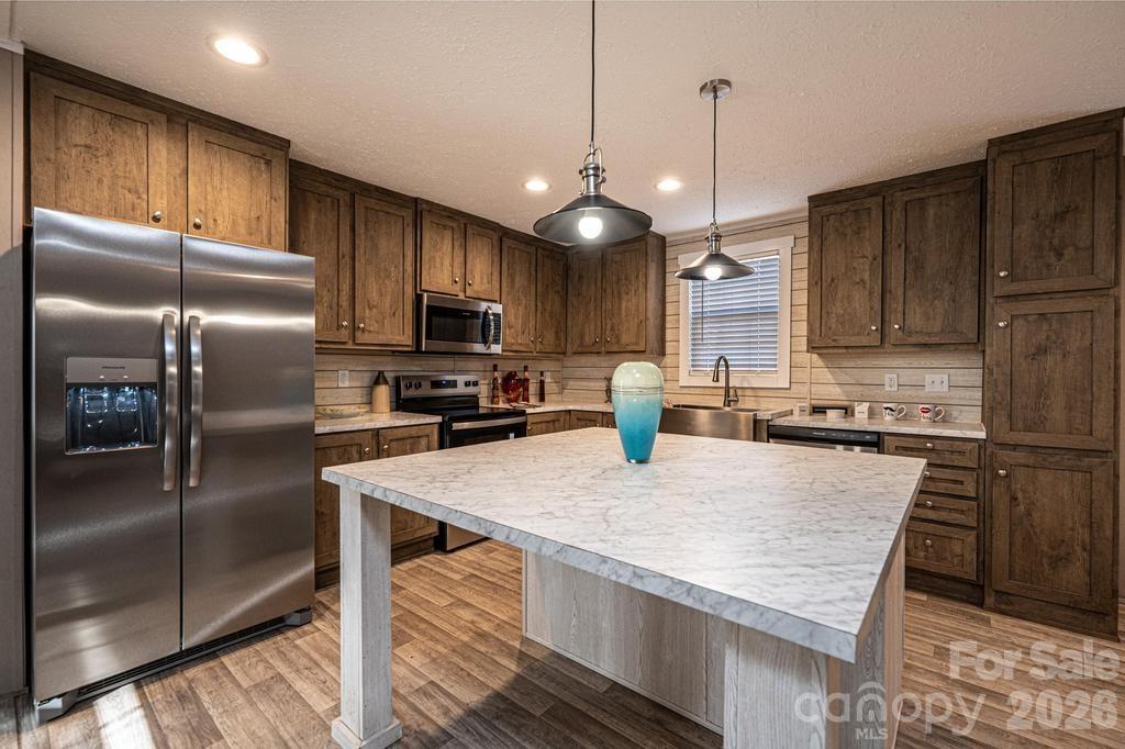1070 Cottrell Hill Road Lenoir, NC 28645 - Photo 7 of 41 a kitchen with kitchen island granite countertop stainless steel appliances and a refrigerator