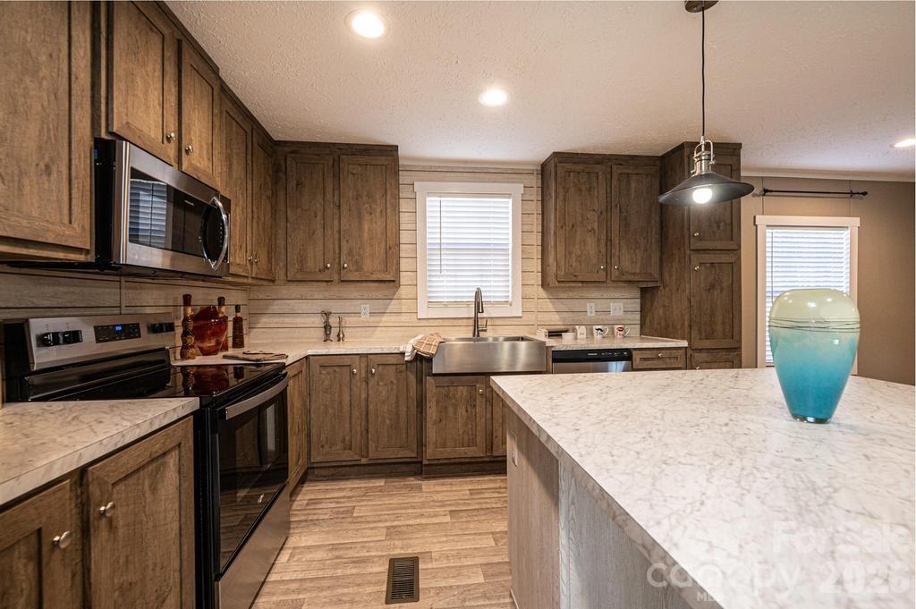 1070 Cottrell Hill Road Lenoir, NC 28645 - Photo 8 of 41 a kitchen with stainless steel appliances granite countertop a sink a stove and cabinets