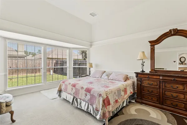 a bedroom with a bed and dresser with mirror