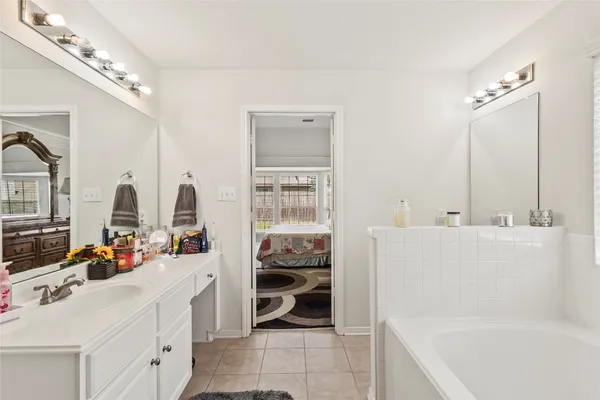 a bathroom with a tub sink and a mirror