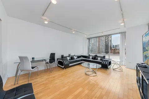 a living room with furniture a flat screen tv and a large window