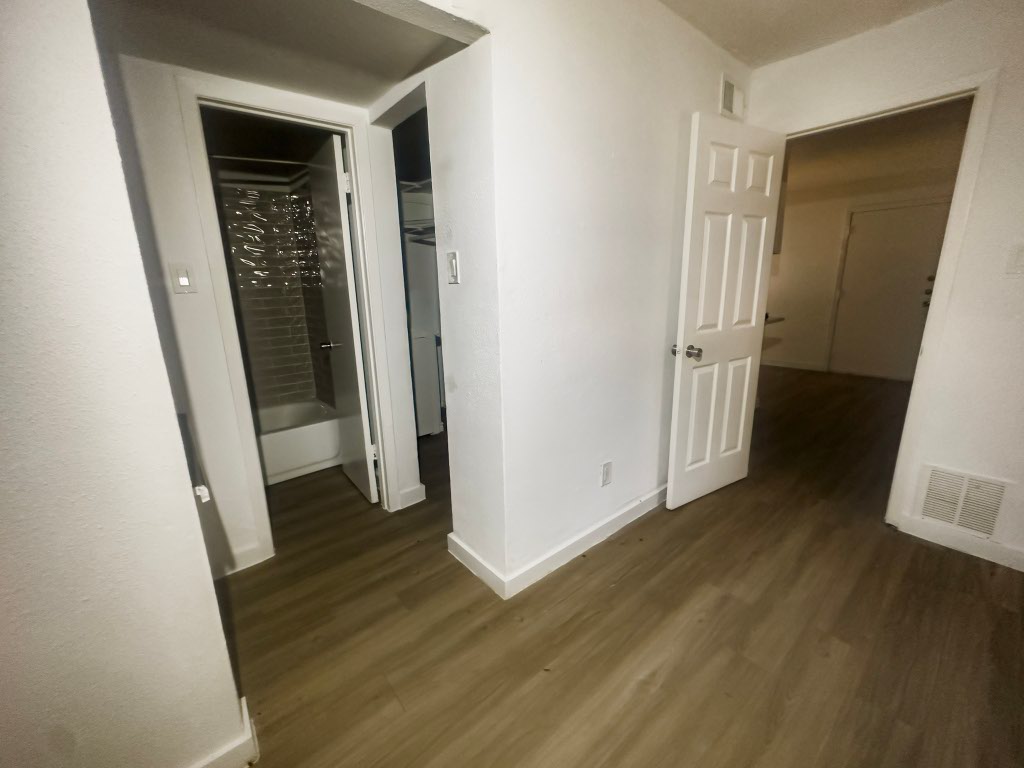 4500 Witham Lane, Unit 104 Austin, TX 78745 - Photo 7 of 27 an empty room with wooden floor and stairs