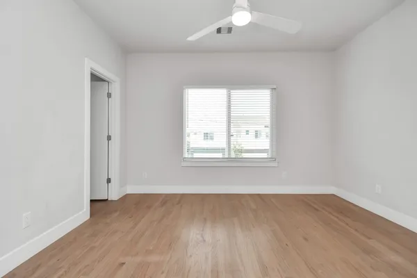 a view of an empty room with wooden floor