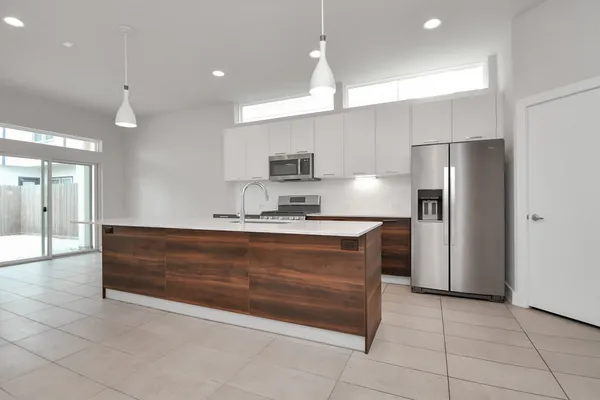 a large kitchen with a refrigerator and a sink