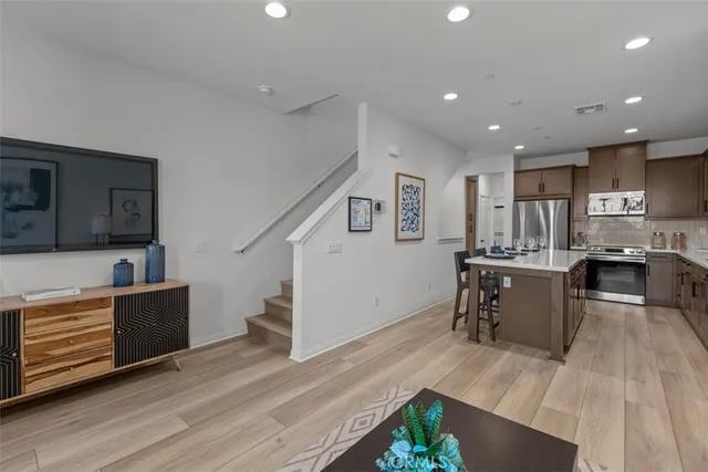 a kitchen with counter top a sink a stove a refrigerator and a potted plant