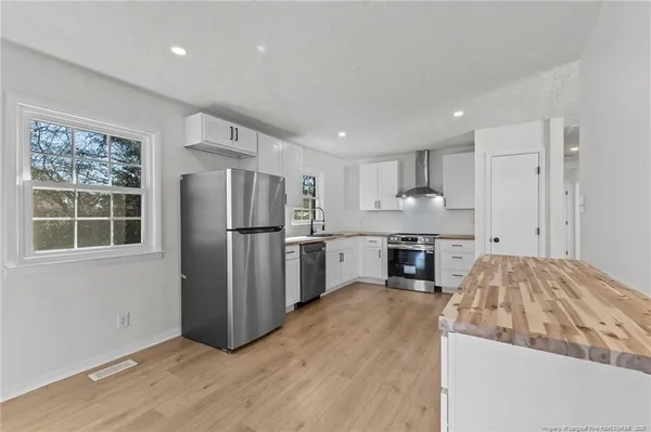 a kitchen with stainless steel appliances granite countertop a refrigerator and a stove