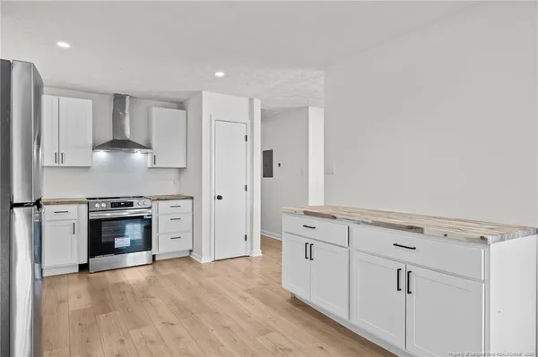 a kitchen with granite countertop white cabinets and stainless steel appliances