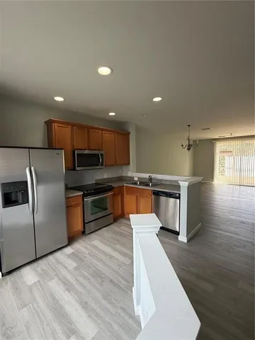 a kitchen with stainless steel appliances kitchen island granite countertop a stove a sink and a refrigerator