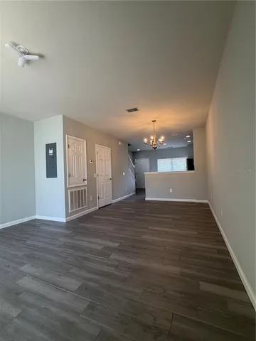 a view of a hallway with wooden floor and a large window