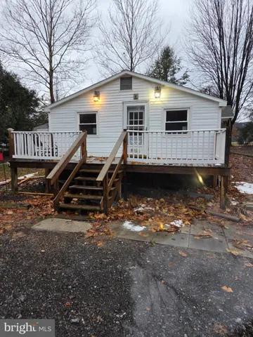 a front view of house with barbeque grill and trees