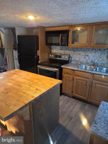 a kitchen with stainless steel appliances kitchen island granite countertop a stove a sink and a microwave