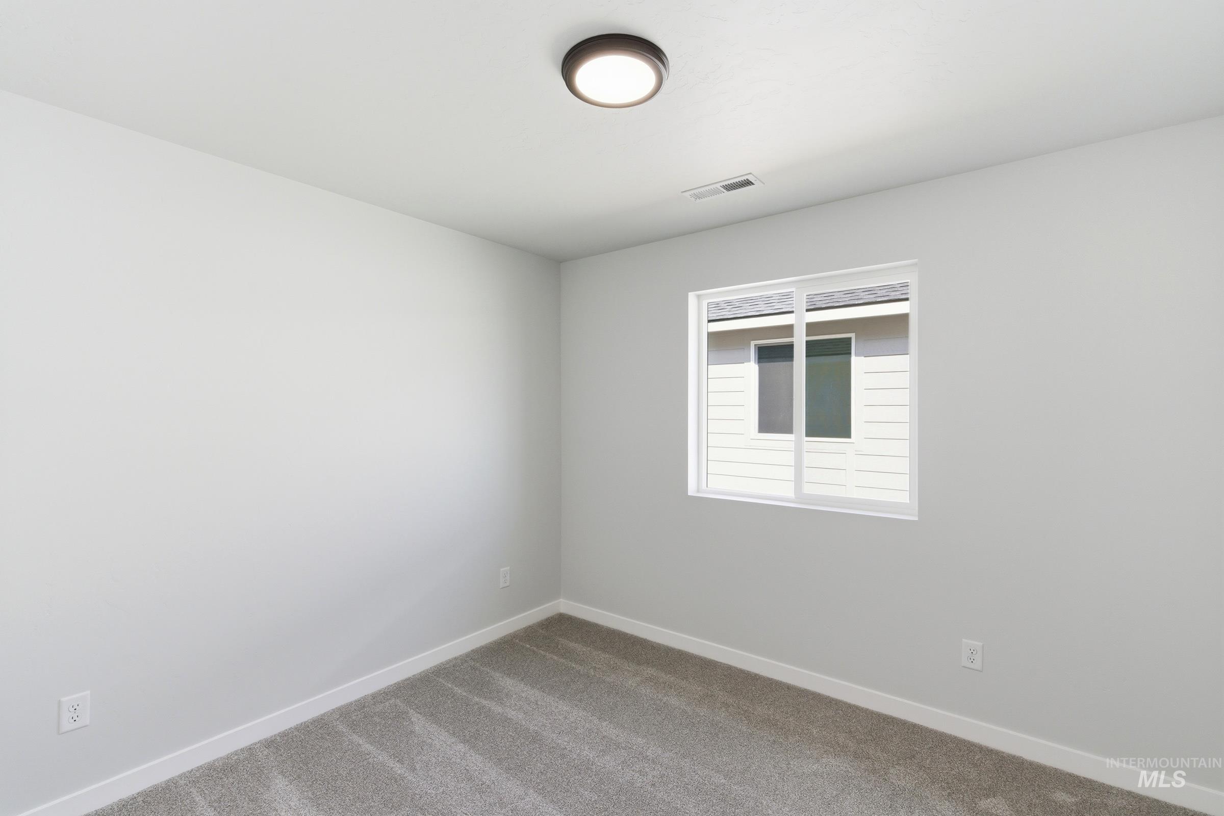 1059 West Jasper Street Meridian, ID 83642 - Photo 15 of 23 Room featuring light gray walls, gray patterned carpet, and a white-framed window
