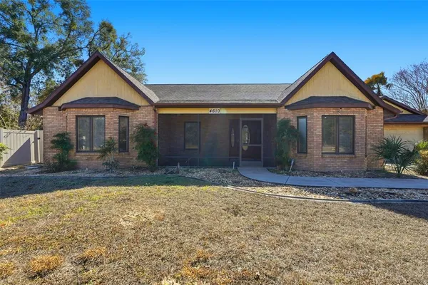 a front view of a house with a yard and trees