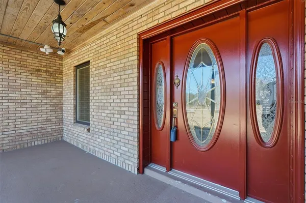 a view of kitchen and empty room with wooden floor