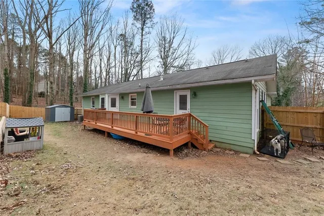 a view of a house with a yard and wooden deck