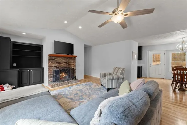 a living room with furniture a flat screen tv and a fireplace