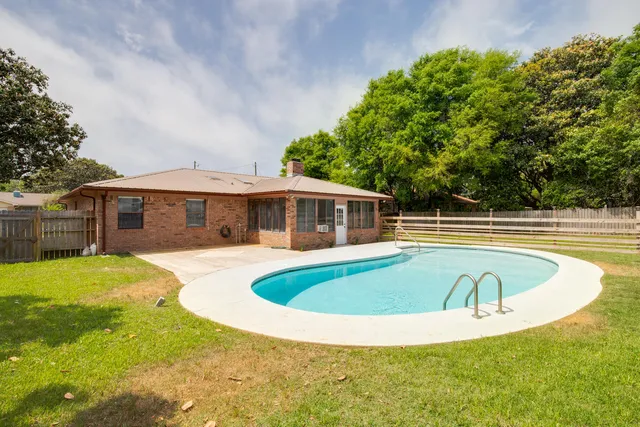 a view of a swimming pool with an outdoor seating and a yard