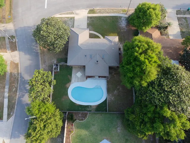 a large white kitchen with cabinets a sink a window and stainless steel appliances