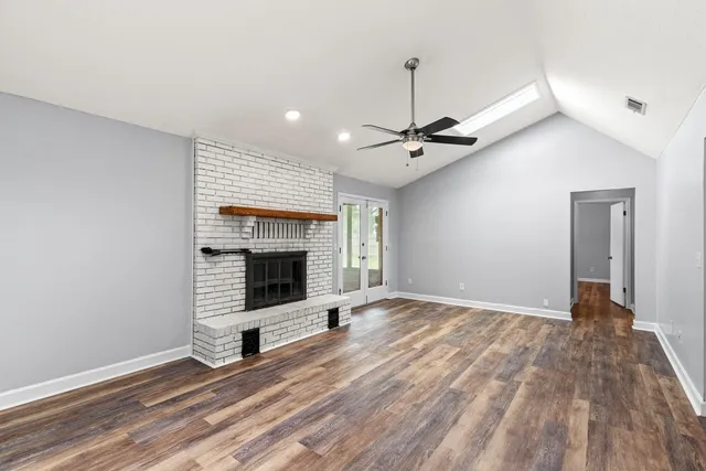 a view of empty room with wooden floor and fireplace