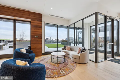 a living room with furniture a large window and a potted plant